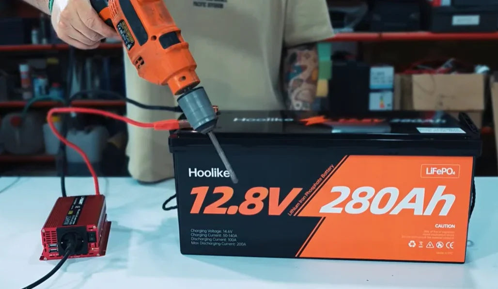 12.8V 280Ah LiFePO4 battery being tested with power tool in workshop